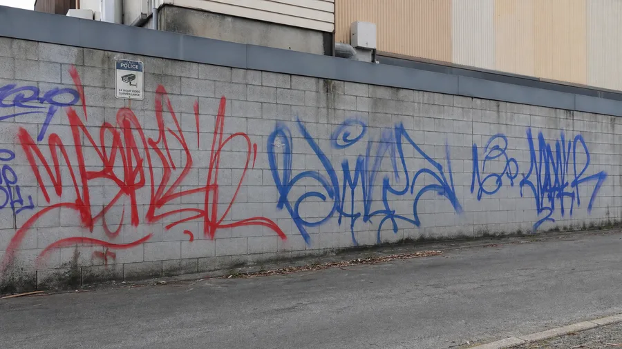 Commercial wall covered in spray-paint graffiti tags