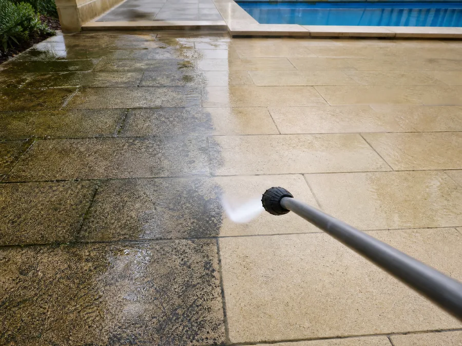 High-pressure lance cleaning limestone paving around a Perth backyard patio